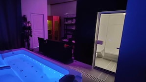 A room with a massage chair, a small table, and a glass door leading to a storage area. - Le Translon  (Saint-Pierre-Aigle)