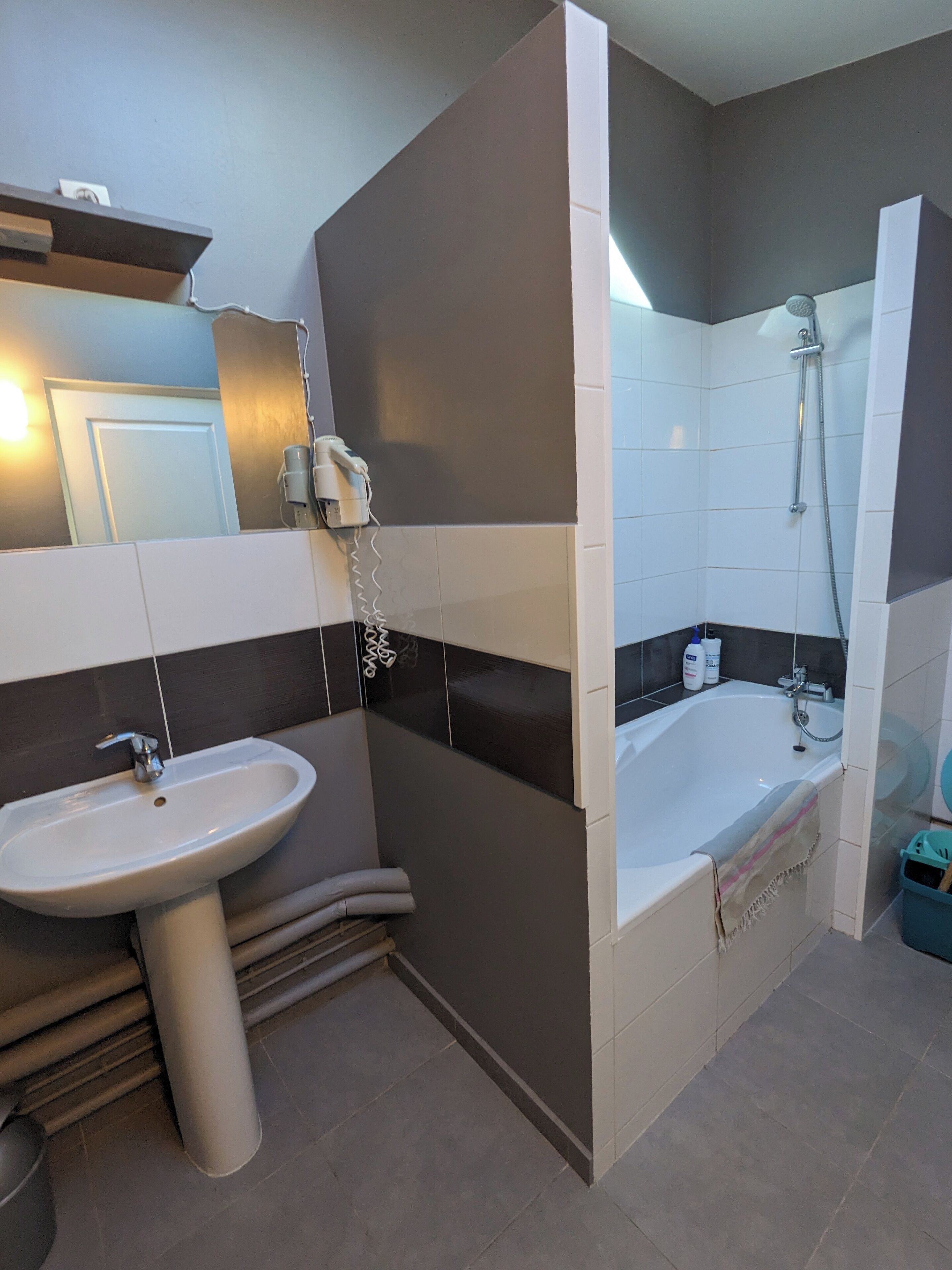 Une salle de bain moderne avec un lavabo, un miroir et un espace douche.