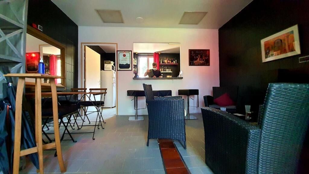 Un espacio habitable compacto con comedor, barra y asientos.