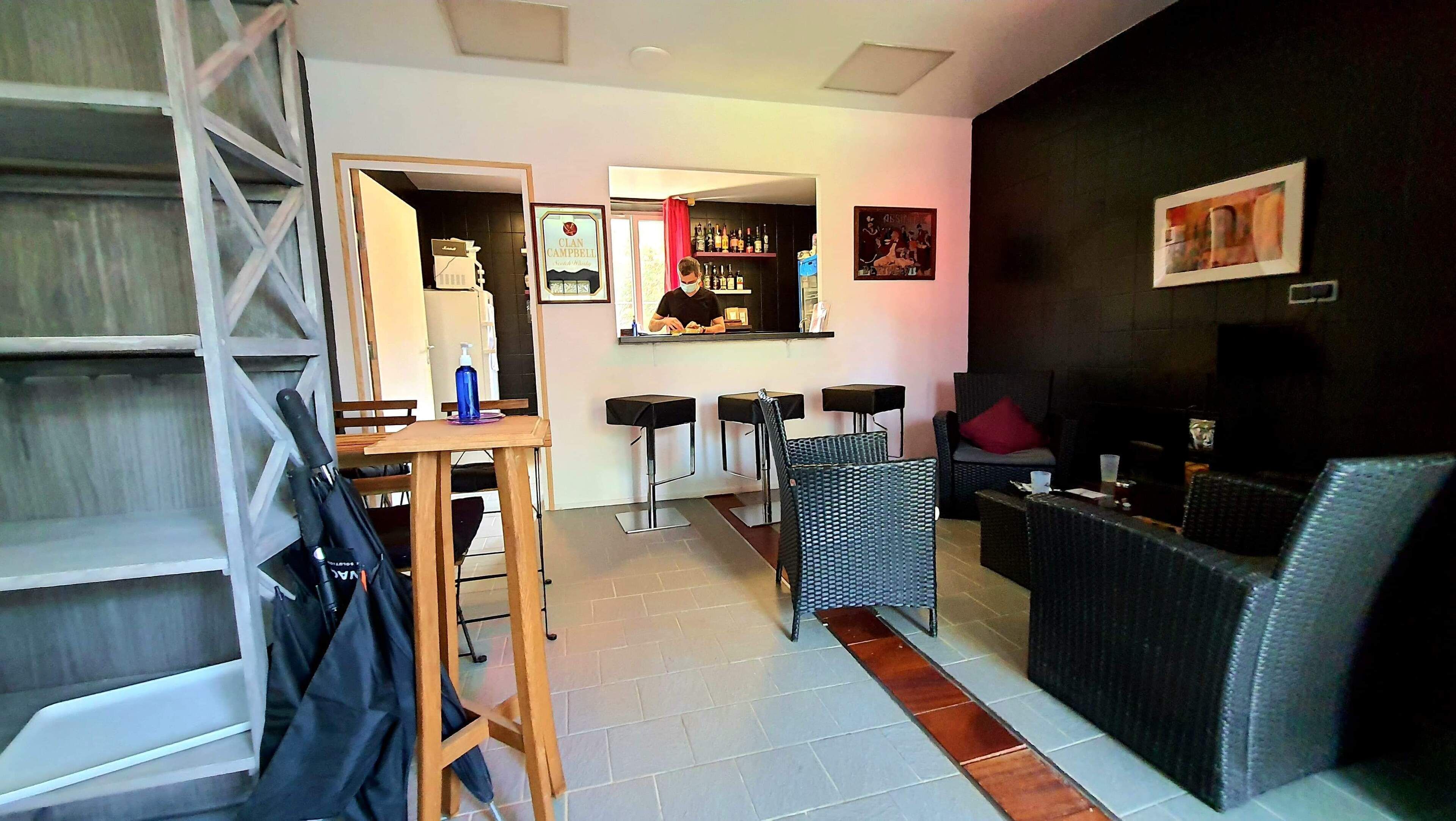 Un salon moderne avec un coin bar, un canapé et une table à manger.