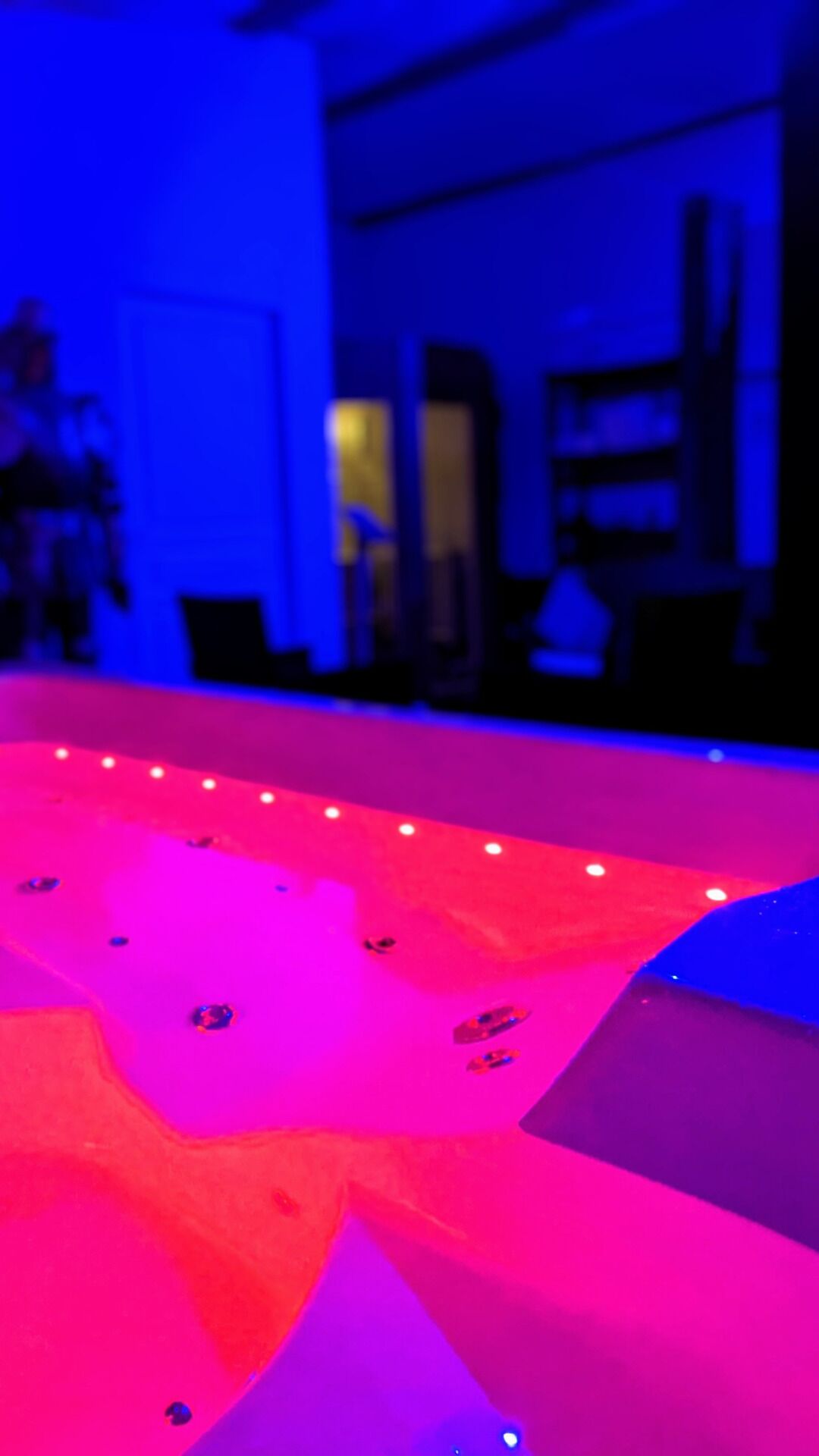 A room with a large, colorful, illuminated floor design.