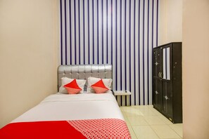 A hotel room with a bed, a nightstand, a wardrobe, and a striped wall.
