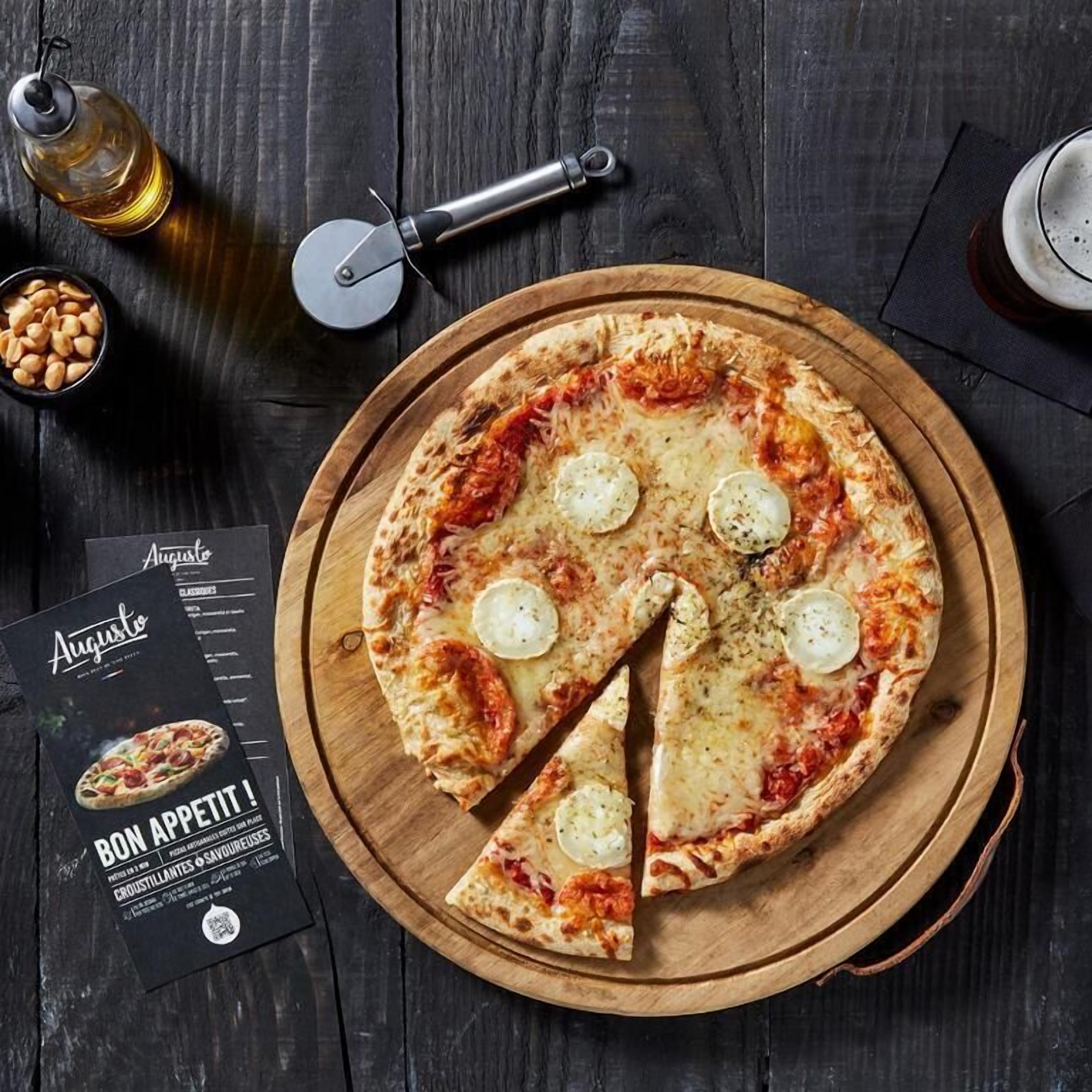 Una pizza sobre una tabla de madera con un cortador de pizza y un menú al lado.