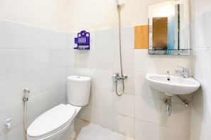 A bathroom with a toilet, a shower, and a sink.
