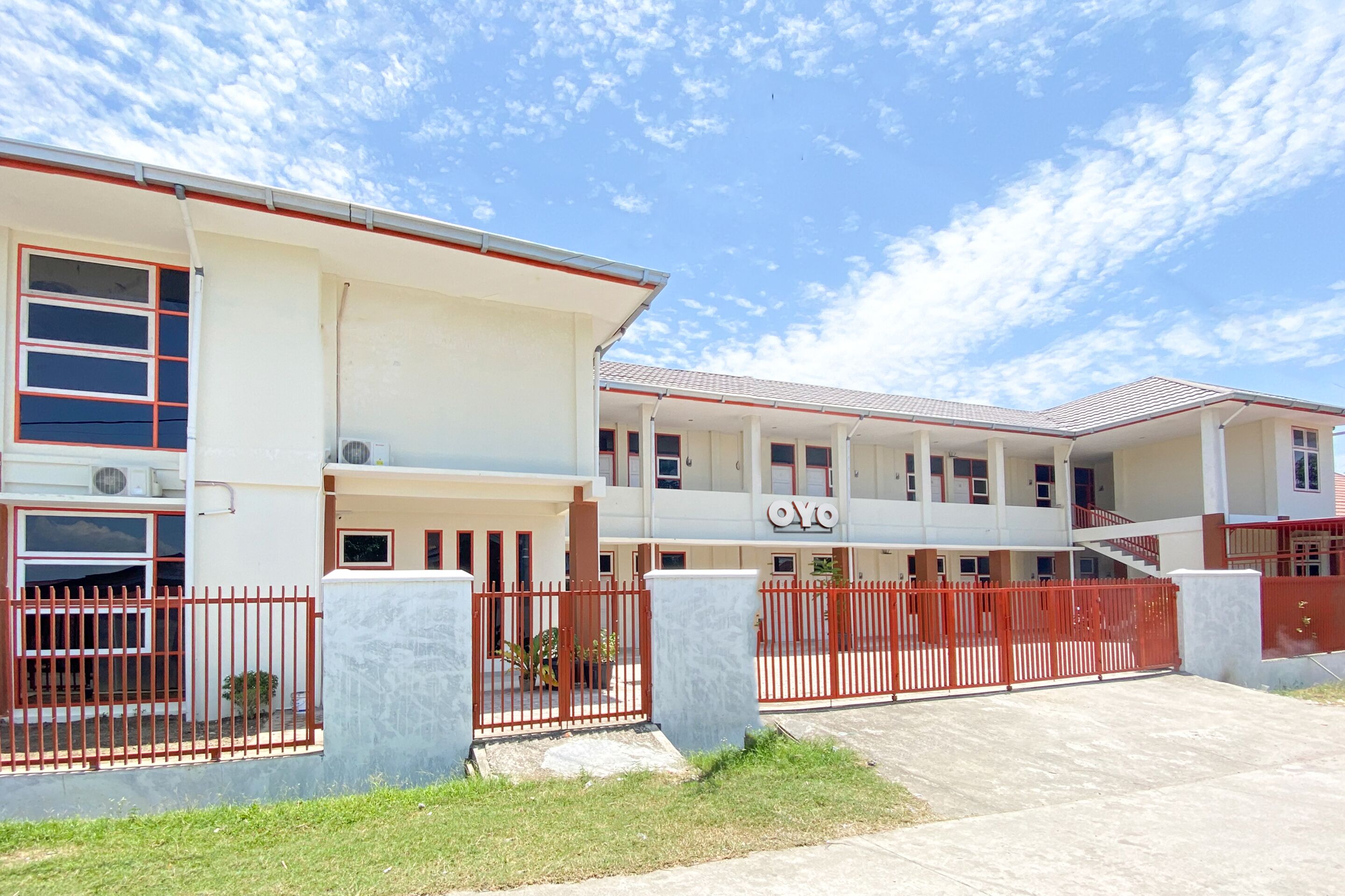 A two-story building with a red gate and a sign that reads "OYO".