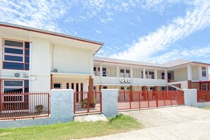 A two-story building with a red gate and a sign that reads "OYO".