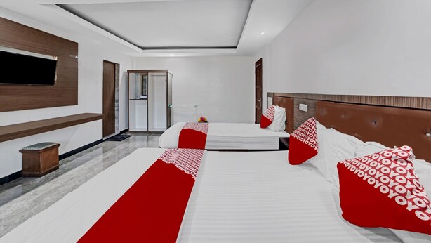 A hotel room with a large bed, a TV mounted on the wall, and a modern design.