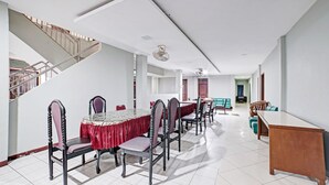 A spacious dining area with a long table, chairs, and a staircase.