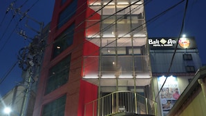 A modern hotel with a red facade and multiple balconies. - ELE Cabin Shinjuku Kabukicho (Tokyo)