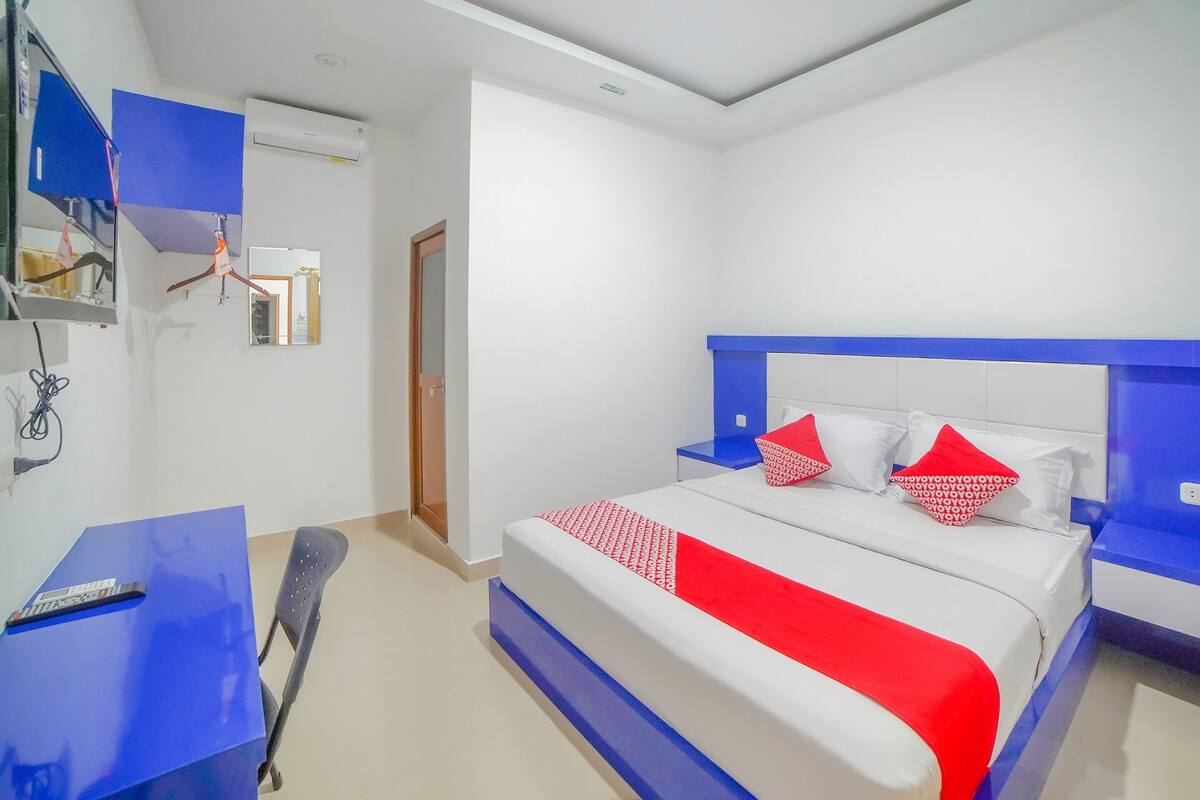 Hotellihuone, jossa on sänky, työpöytä, tuoli ja vaatekaappi.