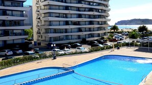 A modern hotel with a pool area, multiple balconies, and a view of the sea. - ROCAMAURA I D 1-2 (Estartit)