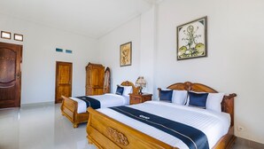 Una habitación de hotel con dos camas de madera, un armario de madera y un cuadro enmarcado en la pared.