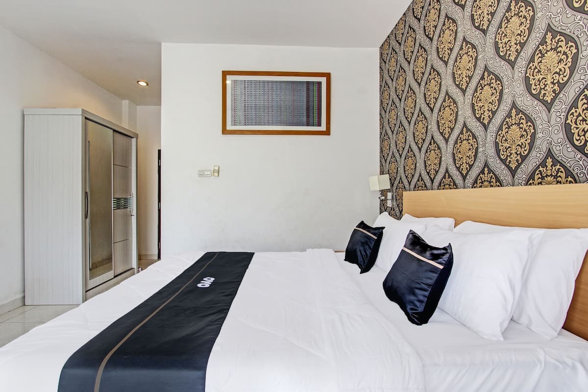 Habitación de hotel con cama, armario y pared con diseño.