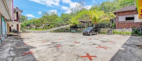 A parking area with marked spaces and a building with a tiled roof.