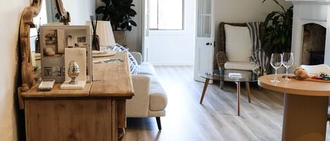 A living room with a wooden coffee table, a glass table, a sofa, and a fireplace.