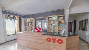 Un mostrador de recepción con el nombre "OYO" y un letrero que indica "RECEPCCIÓN".