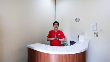 A reception desk with a wooden finish and a white marble top.