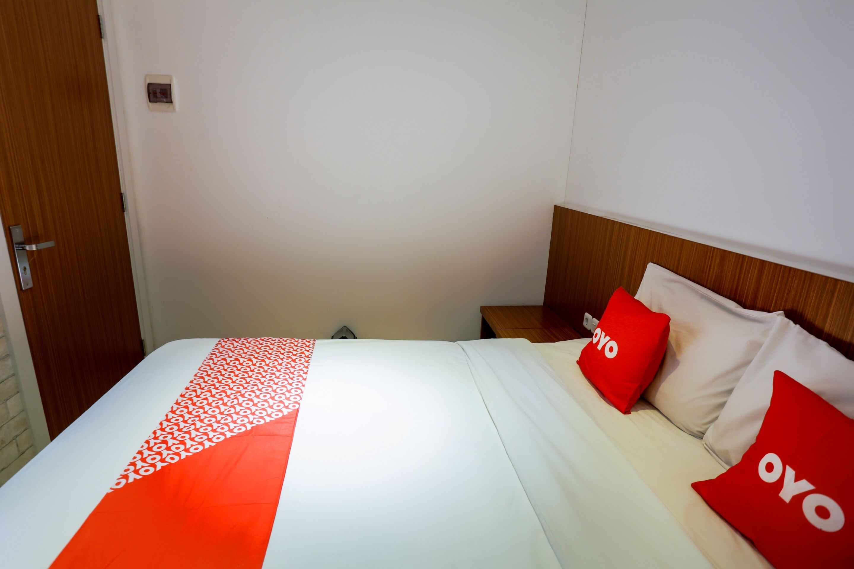 A hotel room with a bed, two nightstands, and a wooden headboard.