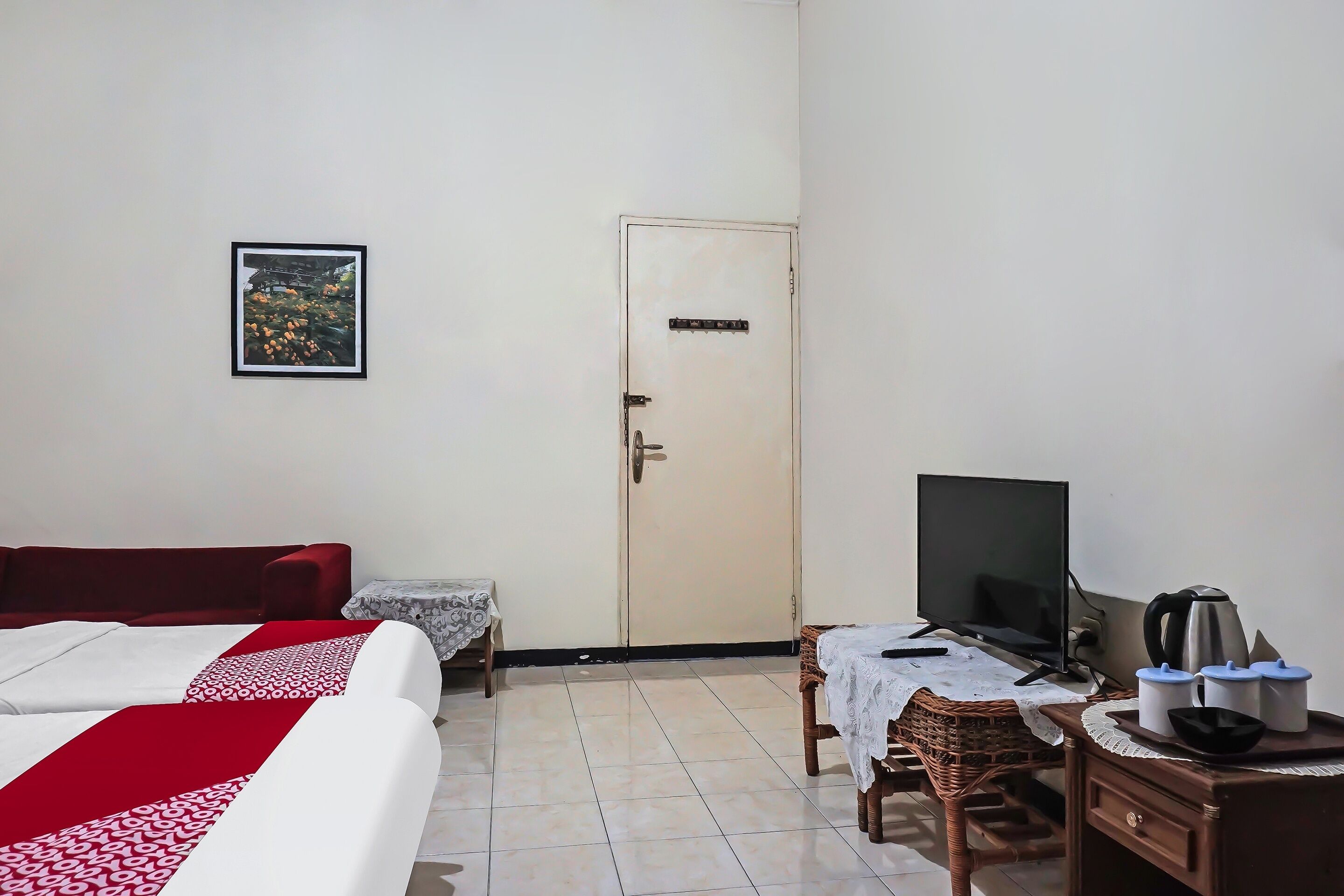 A hotel room with a bed, a TV, a coffee maker, and a small table.