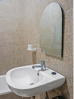 A bathroom with a white sink, a mirror, and a cup holder.
