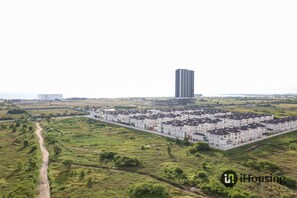 Una zona residencial con una hilera de casas adosadas blancas y un edificio alto al fondo.