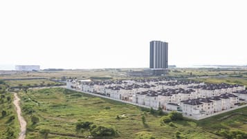 A residential area with a row of white townhouses and a tall building in the background.