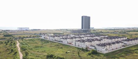 Una zona residencial con una hilera de casas adosadas blancas y un edificio alto al fondo.