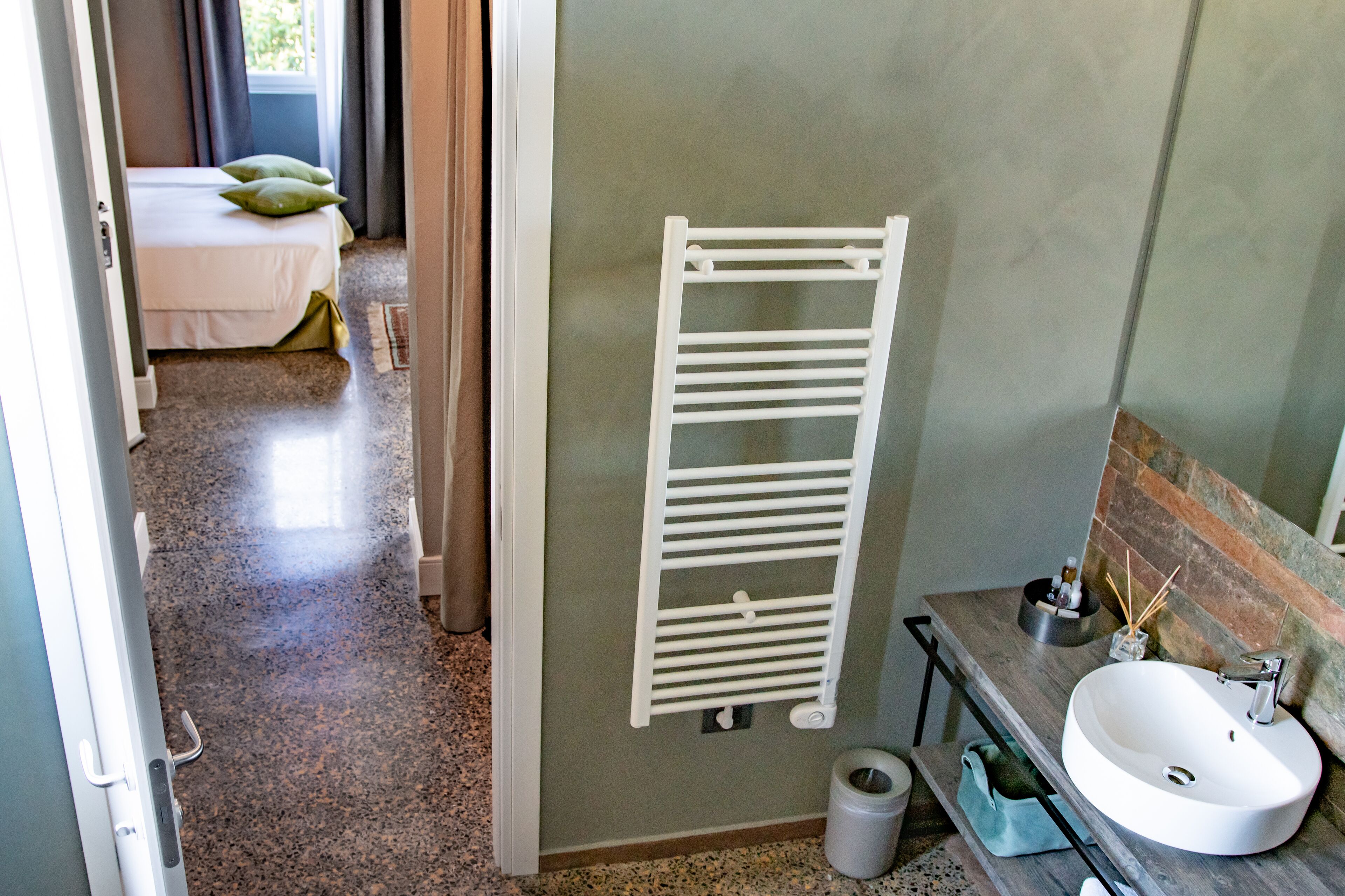 A bathroom with a white sink, a towel rack, and a toilet.