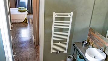 A bathroom with a white sink, a towel rack, and a toilet.
