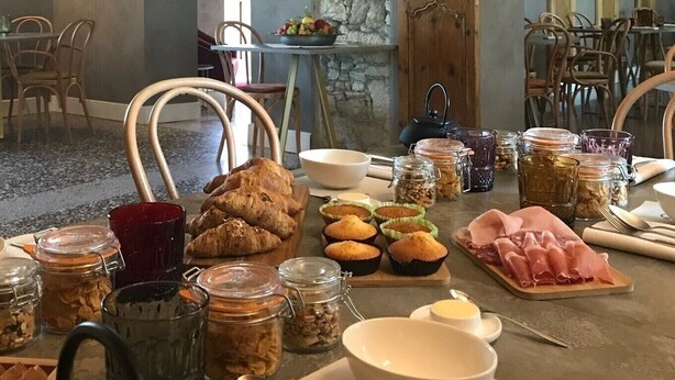 Un bufé de desayuno con bollería, muffins y carnes.
