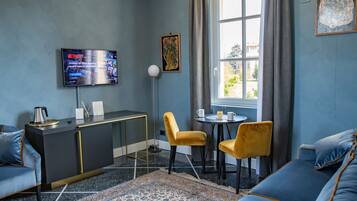 Deluxe Quadruple Room | Living area | 42-inch flat-screen TV with satellite channels, TV