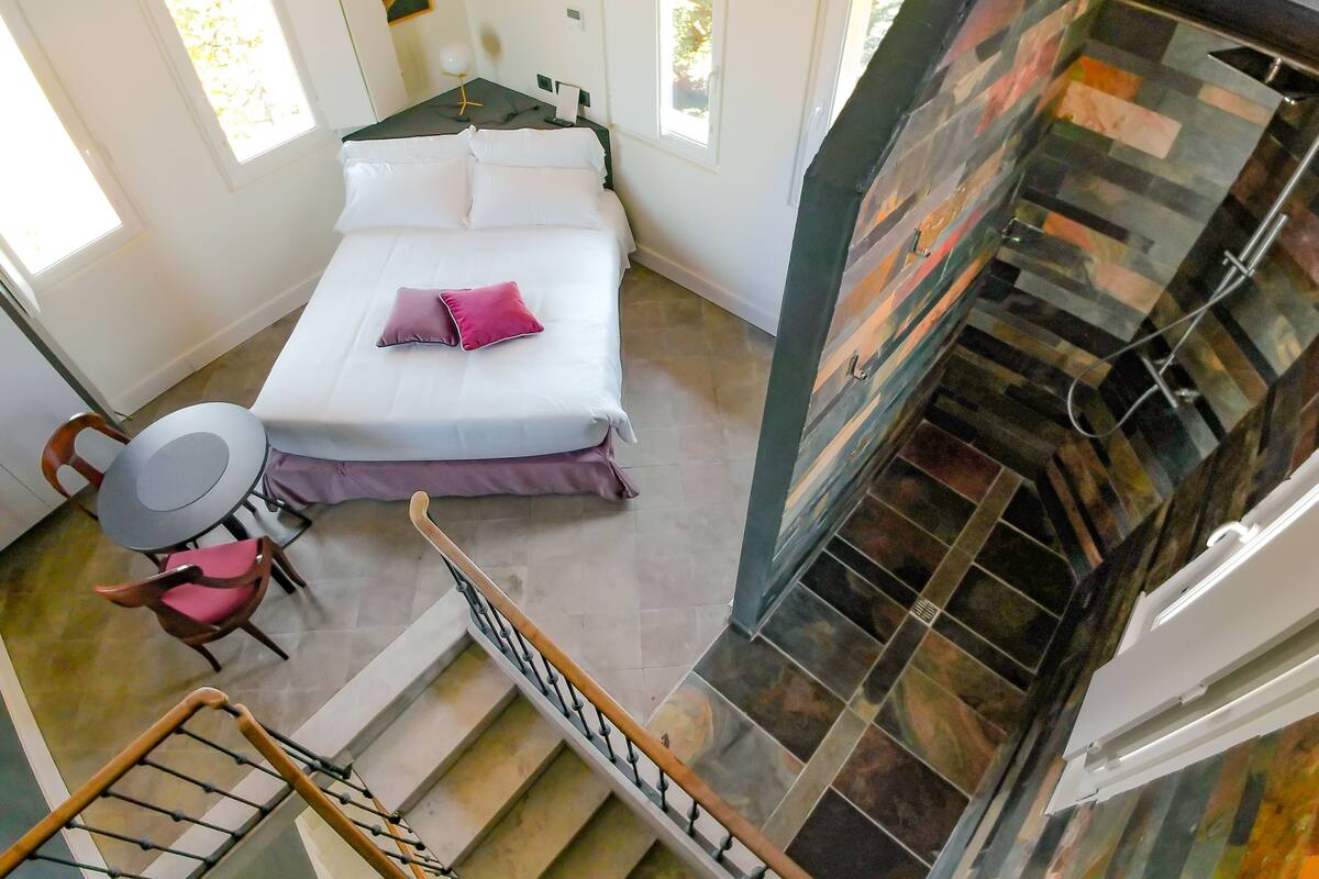 Ein Schlafzimmer mit einem Bett, einem Sessel, einem Tisch und einem Kamin.