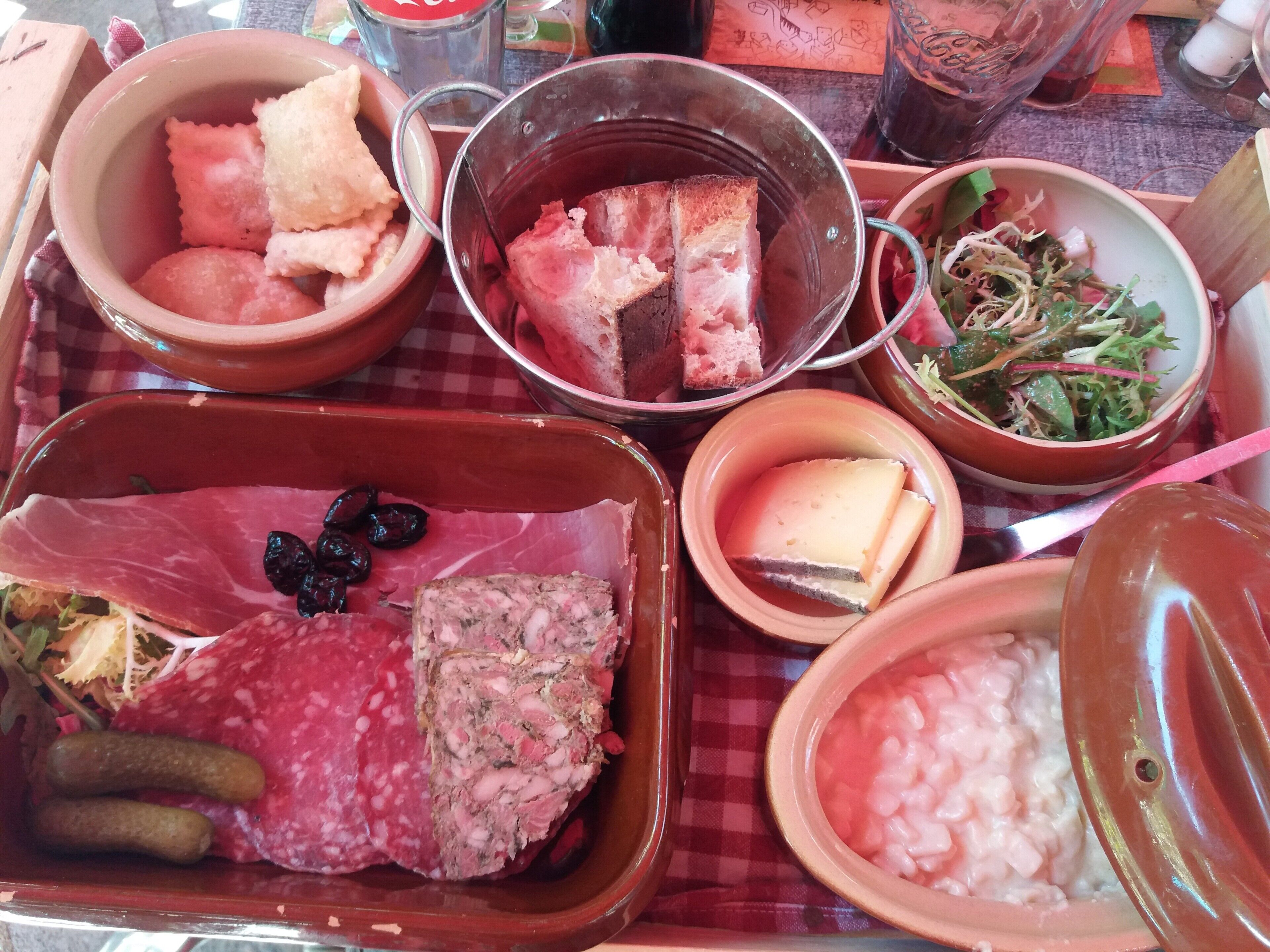 A variety of food items on a tray, including meats, cheeses, and vegetables.