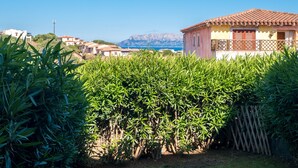 Un quartier résidentiel situé sur la côte, avec des maisons, une montagne en arrière-plan et une végétation luxuriante au premier plan.