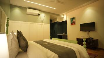 A bedroom with a bed, a TV, an air conditioner, and a ceiling fan.
