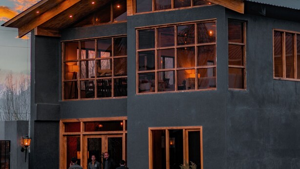 Un bâtiment moderne à deux étages, doté de grandes fenêtres et d’une façade en bois.