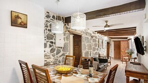 A dining area with a geometric patterned tablecloth, wooden chairs, a fruit bowl, and a wine glass. - Vacation Home "La Casa Nueva" with Mountain View, Whirlpool & Wi-Fi (Fataga)