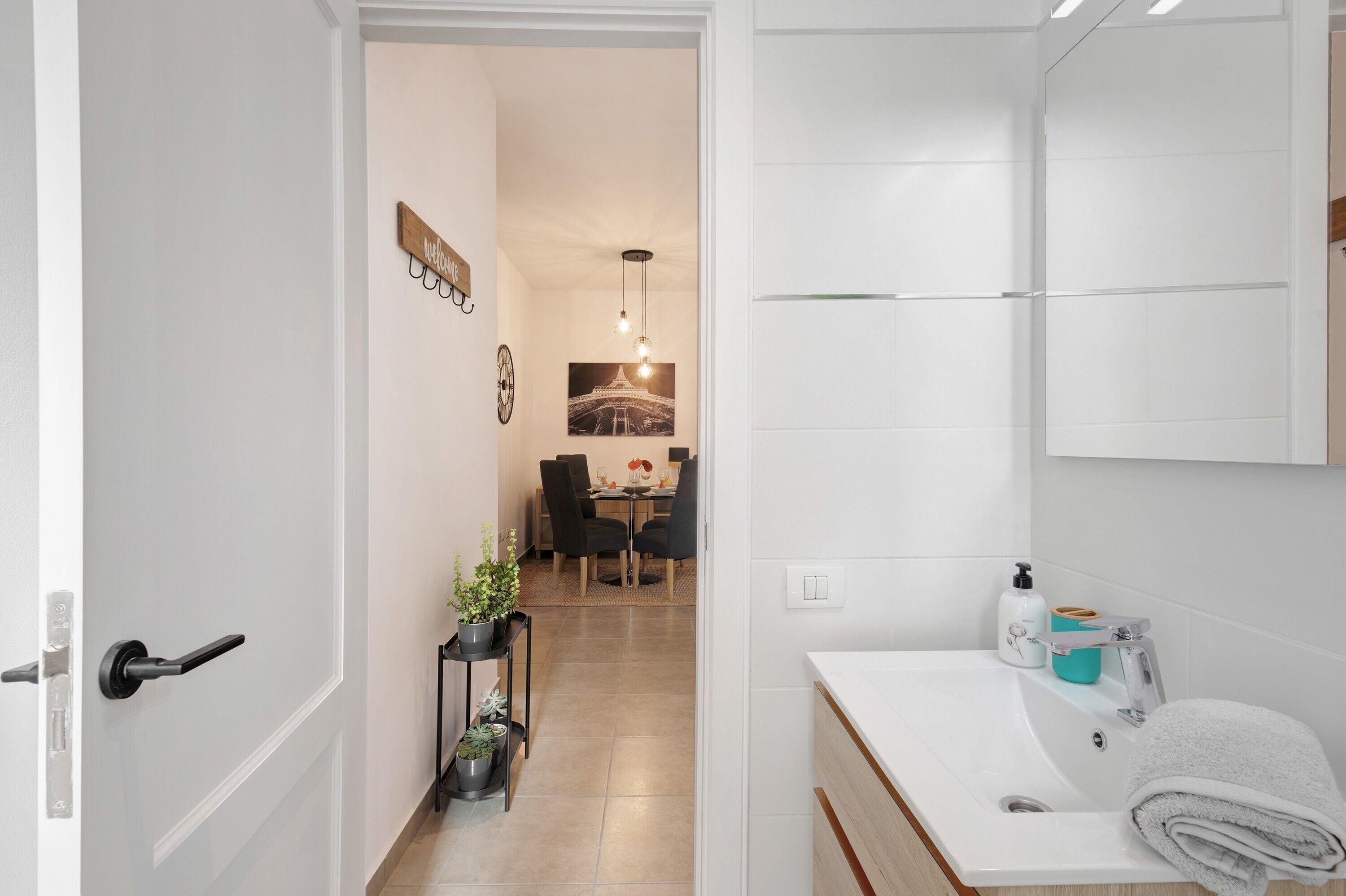 Un baño moderno con un lavamanos blanco, una toalla y un espejo.