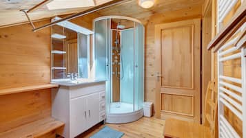A compact bathroom with a shower, a sink, and a mirror.