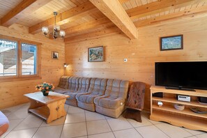 Un intérieur en bois avec un canapé, un téléviseur et des œuvres d’art accrochées aux murs.