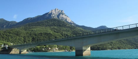 A bridge over a body of water with a mountain in the background.