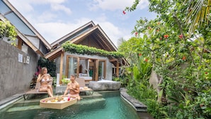 A pool area with two lounge chairs, a hot tub, and lush greenery. - Wana Bucu Villas by GenuineHost (Ubud)