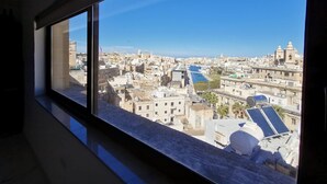 Una vista urbana a través d'una finestra, amb una visió clara d'edificis, un riu i una església destacada.