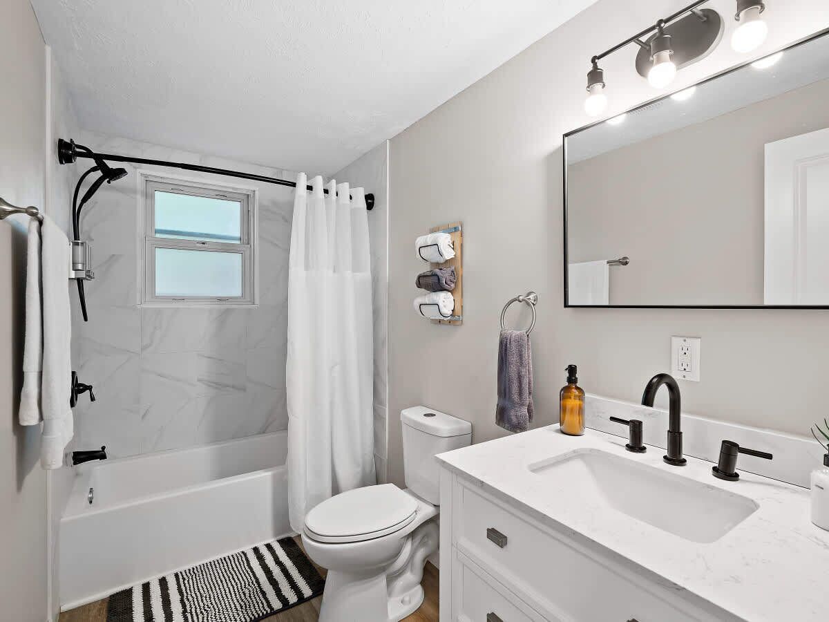 A modern bathroom with a bathtub, toilet, and sink.