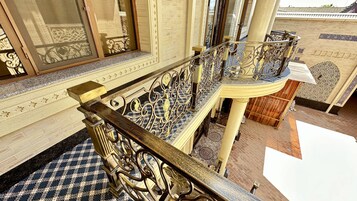 Una imponente escalera con barandillas de metal ornamentadas y un suelo a cuadros.