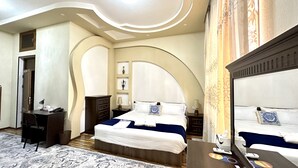 Une chambre d’hôtel avec un grand lit, un bureau et une armoire.