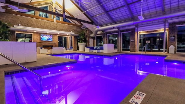 An indoor swimming pool with a modern design, including a brick wall and a flat roof. - The Queen of Dublin | Luxury 2BR Near Bridge Park | Pool + Gym (Dublin)