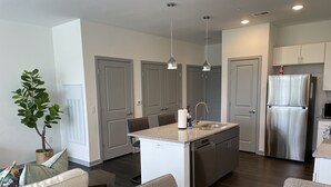 A modern kitchen with a central island, stainless steel appliances, and pendant lighting. - The Queen of Dublin | Luxury 2BR Near Bridge Park | Pool + Gym (Dublin)