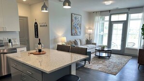 A modern kitchen with a granite countertop, stainless steel appliances, and pendant lighting. - Dublin 1BR | Pets OK | King bed | 0 stairs (Dublin)