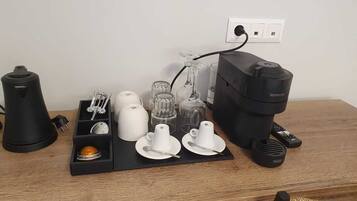 Een keukentrap met een koffiezetapparaat, een waterkoker en diverse glazen.